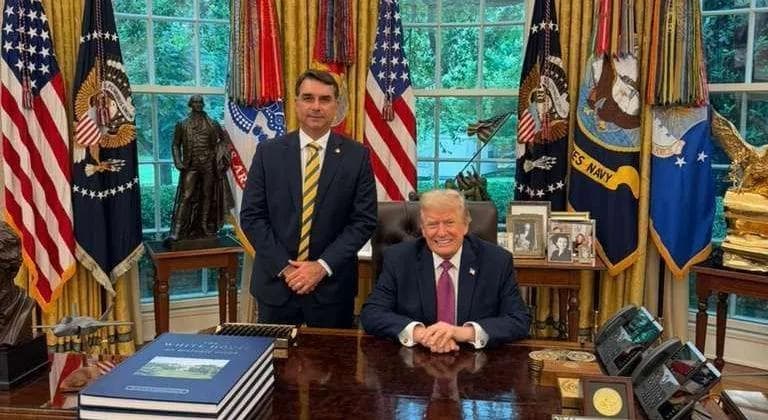 O senador Flávio Bolsonaro ao lado do presidente Donald Trump. • Divulgação